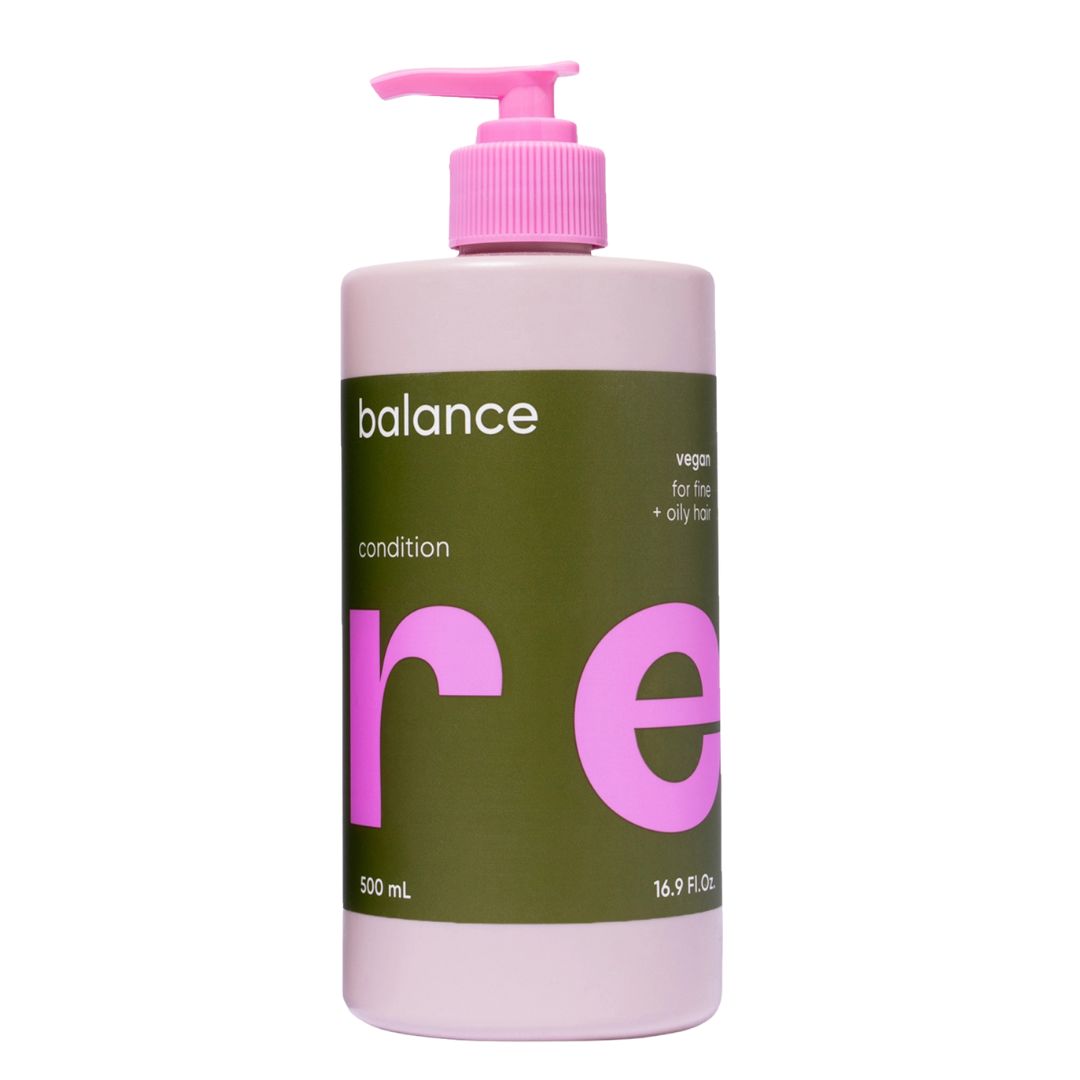 Bottle of balance re conditioner with pink pump on a white background