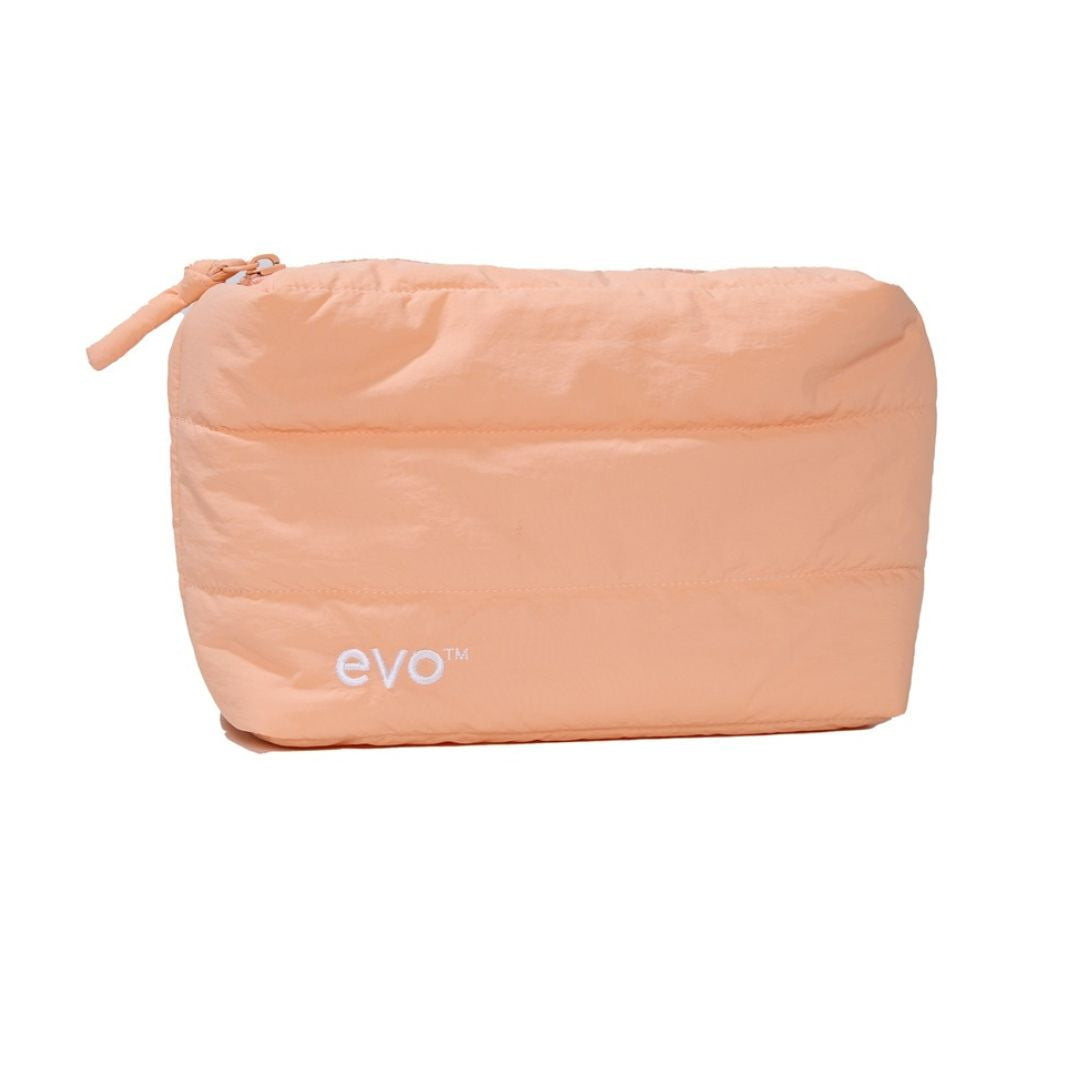 A peach-colored puffy zippered pouch with the brand name 'evo' printed in white near the bottom left, set against a plain white background.