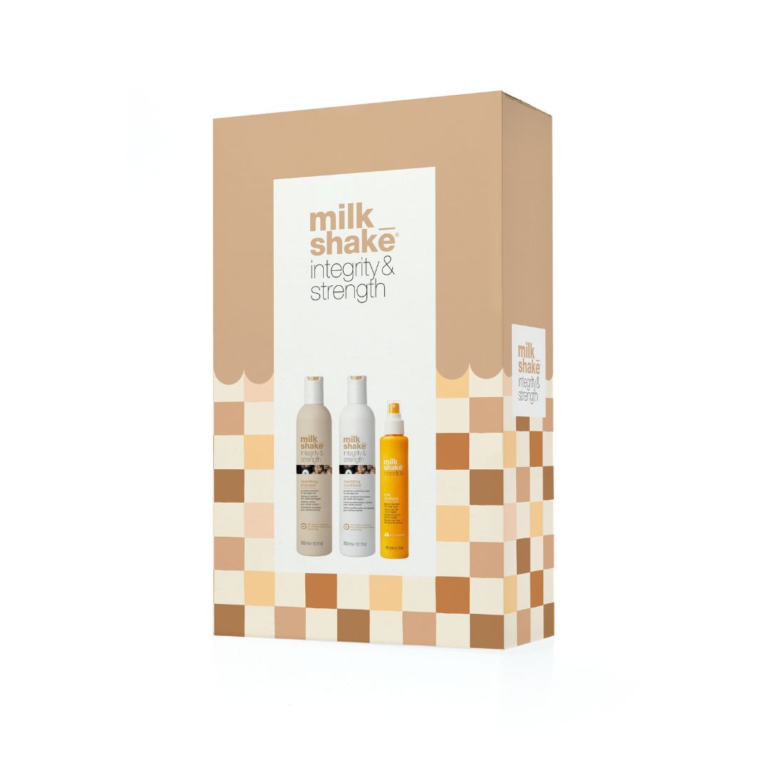Milk Shake Integrity & Strength hair care set in a brown and beige checkered box, featuring two bottles of white shampoo and one bottle of yellow conditioner.