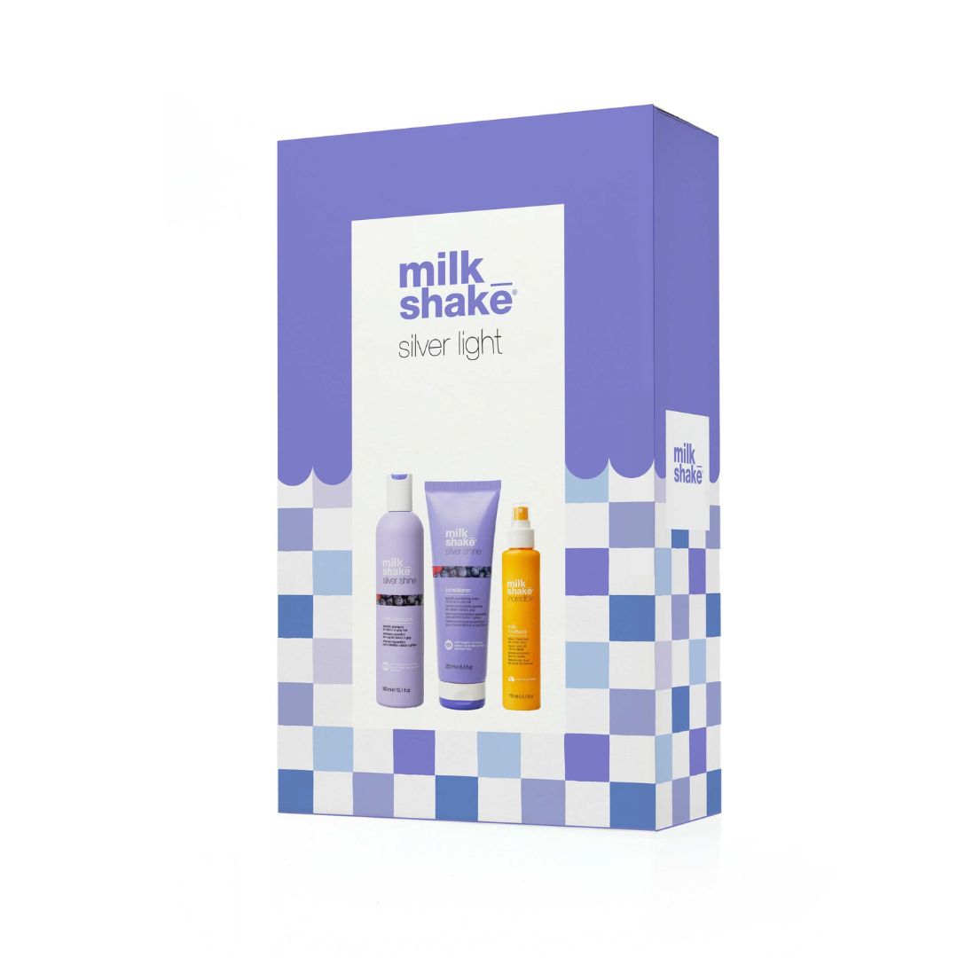 Milk Shake Silver Light hair care set in a purple and white checkered box, featuring a purple shampoo bottle, a purple conditioner tube, and an orange-yellow oil bottle.
