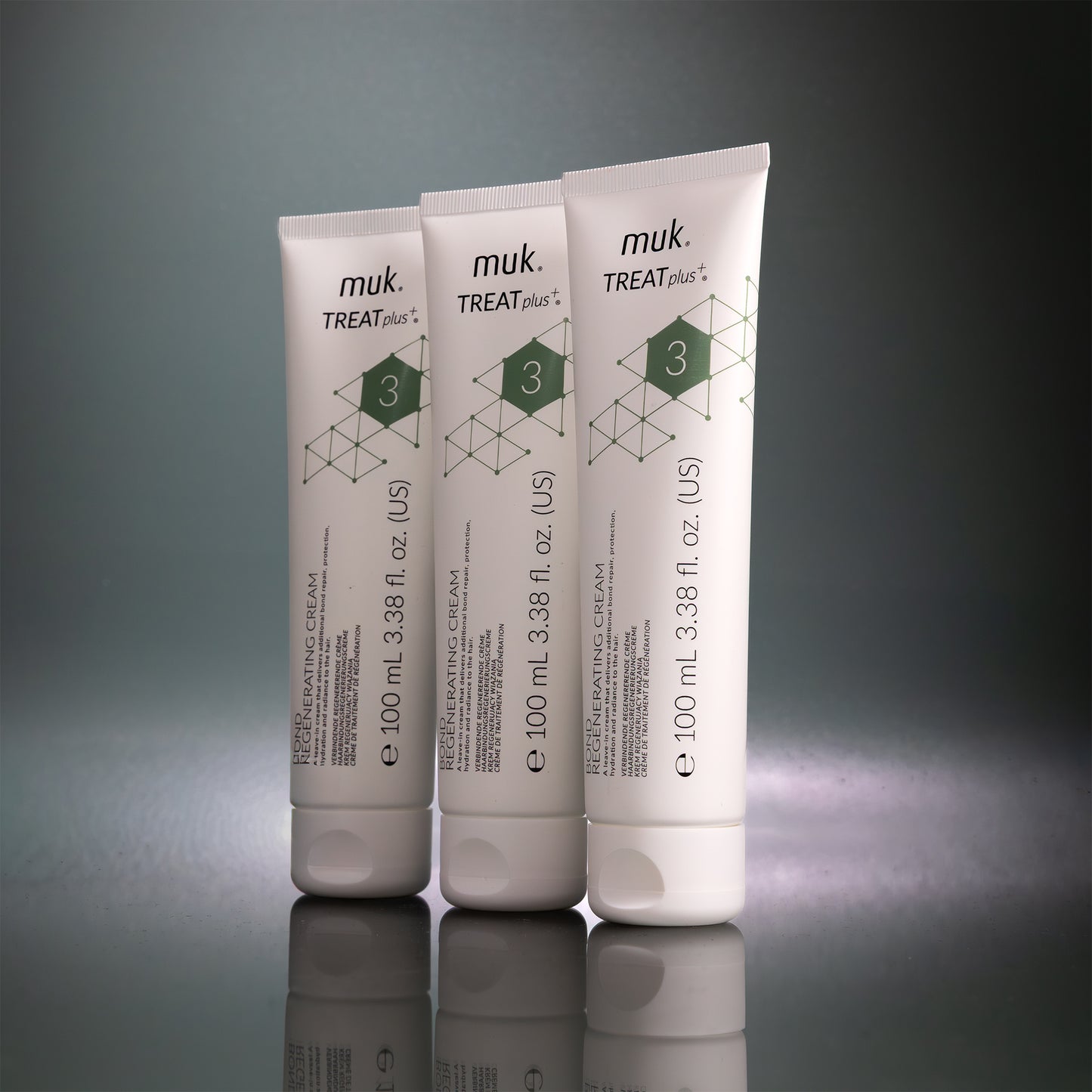 Three muk Treat Plus cream tubes on a reflective surface with a gray background