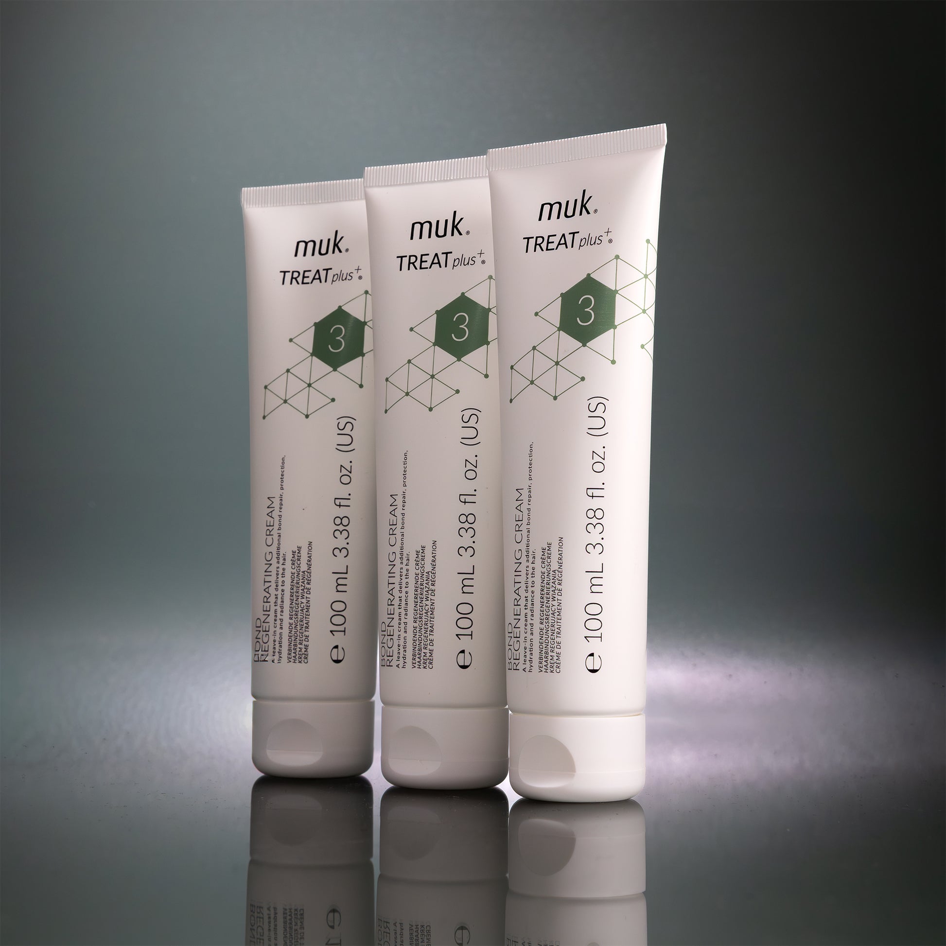 Three muk Treat Plus cream tubes on a reflective surface with a gray background