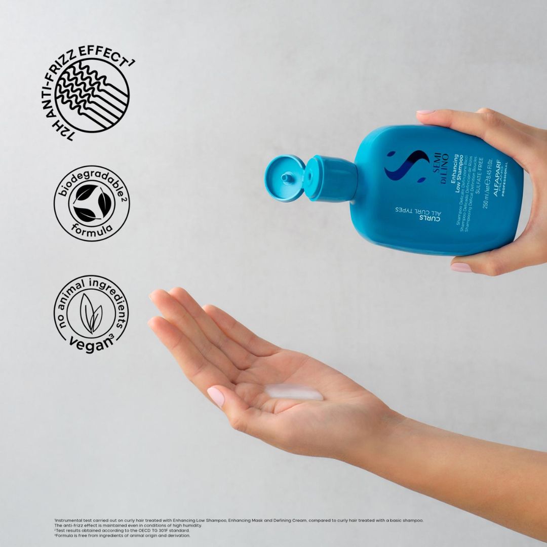 Person applying blue shampoo bottle to hand with ethical branding icons on a light gray background