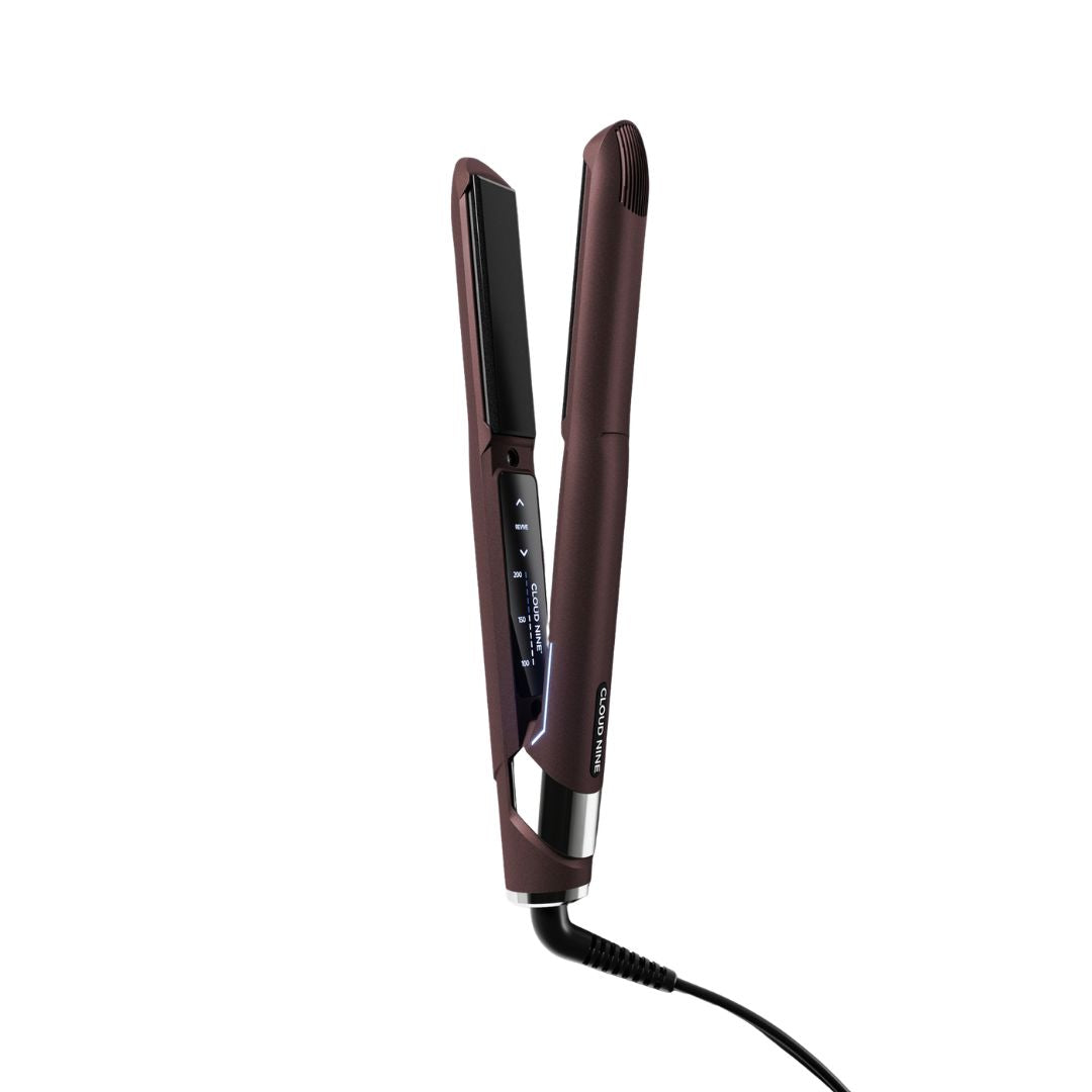 A dark brown flat iron hair straightener with a digital temperature display on the hinge, shown open on a solid white background.