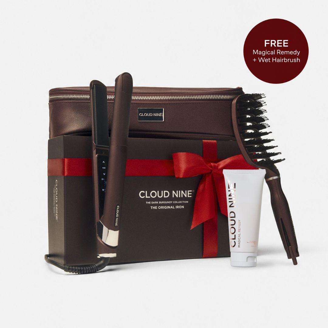 Cloud Nine men's haircare gift set featuring a dark brown hair straightener, styling brush, hair treatment tube, and zippered case wrapped in a red ribbon, with a circular badge reading 'FREE Magical Remedy + Wet Hairbrush'.