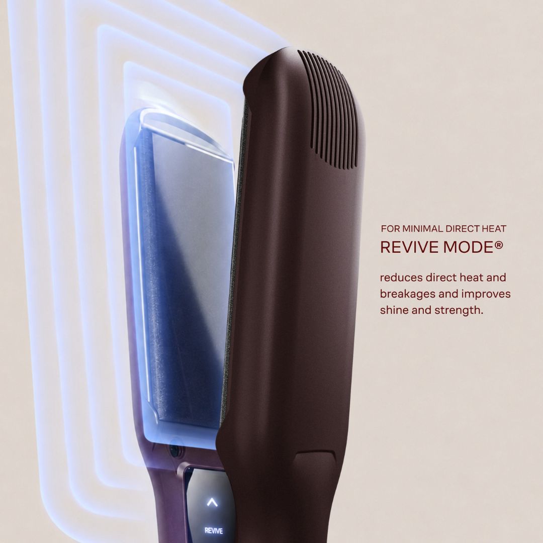 A close-up of a hair straightener in dark brown with a blue interior heating plate, shown with graphic heat-wave lines and text reading 'FOR MINIMAL DIRECT HEAT REVIVE MODE® reduces direct heat and breakages and improves shine and strength.'.