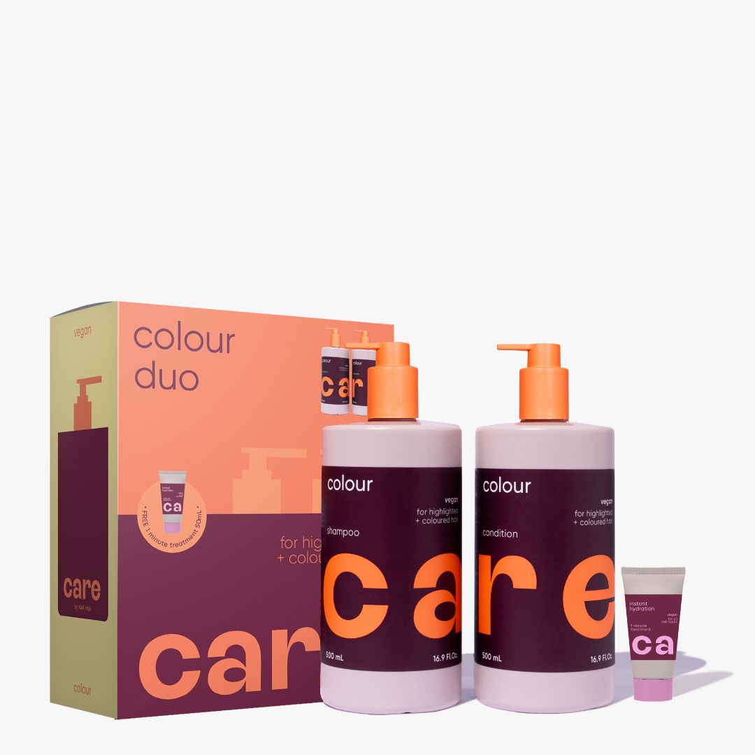 A hair care set featuring two large bottles of shampoo and conditioner with orange pumps, a matching small tube, and a branded box. The packaging uses a color-blocked design in peach, dark purple, and beige, with the brand name 'care' prominently visible.