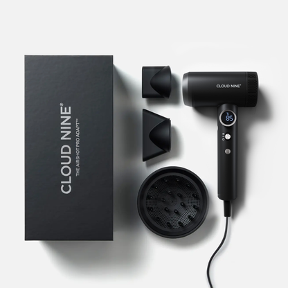Cloud Nine hair dryer set with black accessories and packaging on a light gray background. The set includes a matte black hair dryer with a digital display, two concentrator nozzles, a round diffuser, and a tall rectangular box with the Cloud Nine branding.