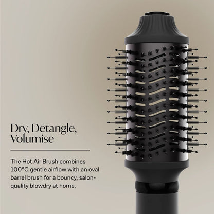 A black hot air brush with multiple bristles and a textured barrel, shown on a warm beige background with descriptive text reading 'Dry, Detangle, Volumise' and a short product feature callout.