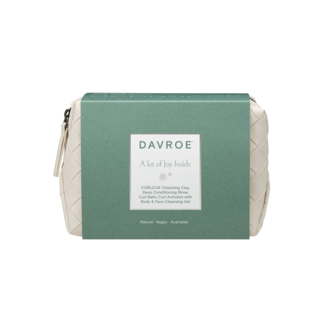 Davroe Curlcise Cleansing Clay in its original green paper packaging, with a small cream-colored woven pouch visible on either side of the box.