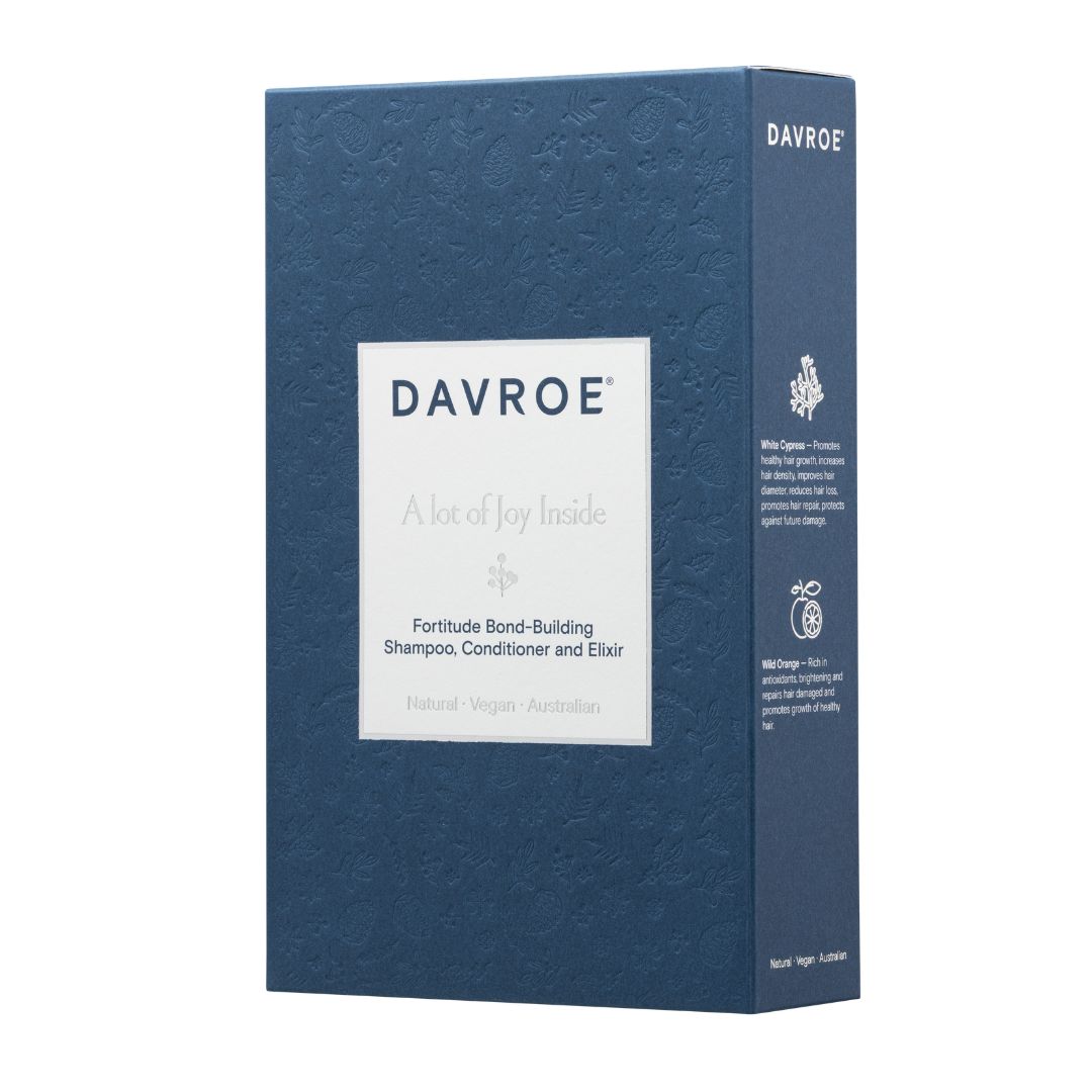 A tall rectangular blue box for Davroe Fortitude Bond-Building Shampoo, Conditioner and Elixir, shown on a plain white background. The front has a white label with the brand name and product details, and the side panel shows additional text and icons.