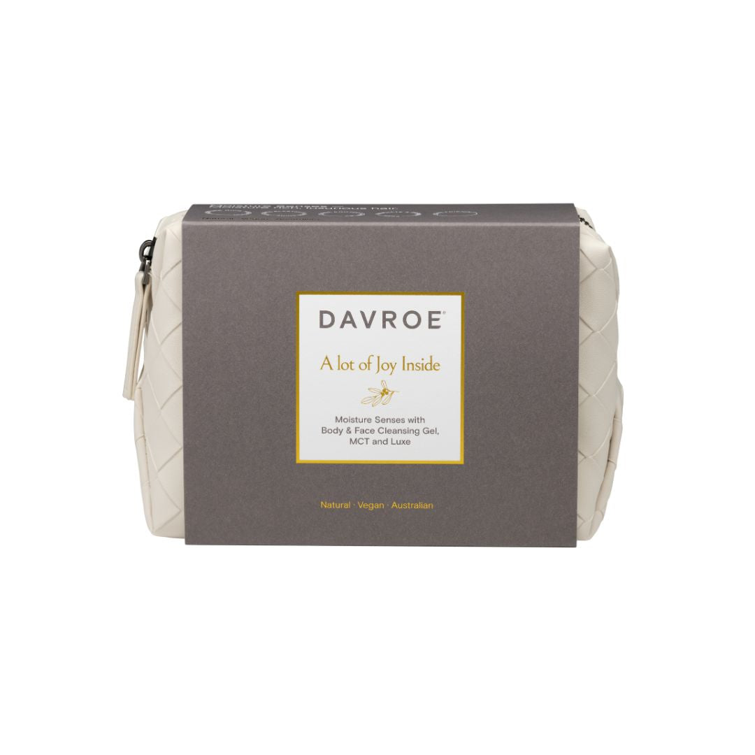 A Davroe 'A lot of joy inside' body and face cleansing gel pouch, featuring a dark brown cardboard sleeve with a white and gold label, set against a plain white background.