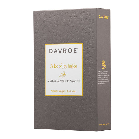 A tall rectangular product box for Davroe, shown on a plain white background. The box is dark gray with a subtle embossed floral pattern, a large white front label with gold border and text, and gold branding on the top and side.