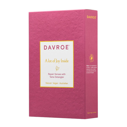 A pink textured box for Davroe Tams Detangler, featuring a white label with gold text and a small tams illustration, shown on a plain white background.