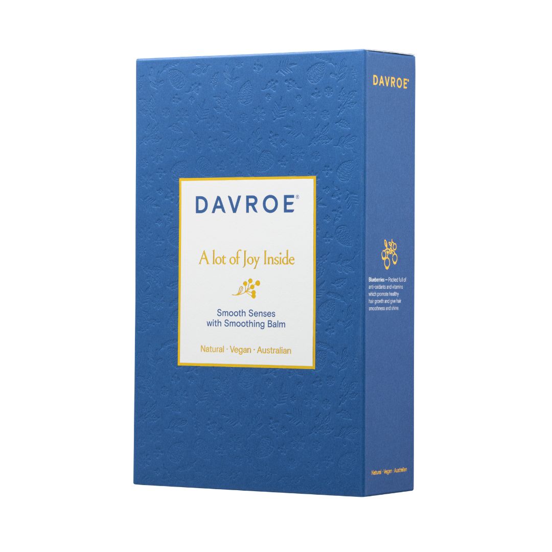 A blue rectangular product box for Davroe Smooth Series with Smoothing Balm, featuring a white front label with gold text and a subtle embossed floral pattern.