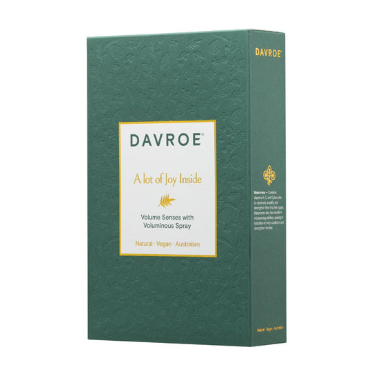 A rectangular green product box for DAVROE Voluminous Spray, featuring a textured embossed pattern, a white label with gold and green text, and gold lettering on the side panel, set against a plain white background.