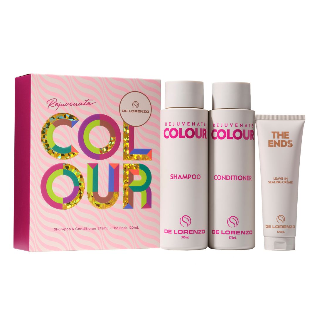 De Lorenzo Colour Rejuvenate hair care set including a pink patterned box, a shampoo bottle, a conditioner bottle, and a leave-in hair cream tube on a white background.