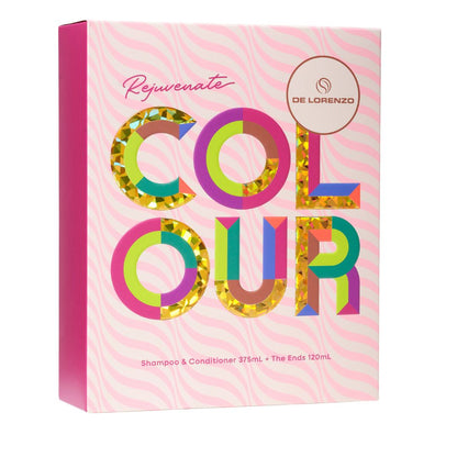 A pink rectangular product box for De Lorenzo Rejuvenate Colour Shampoo & Conditioner. The box features a pink and white wavy pattern background, a solid pink spine, and large, colorful, glitter-filled letters spelling 'COLOUR'.
