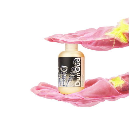 Bottle of DumDum on a pink fabric background