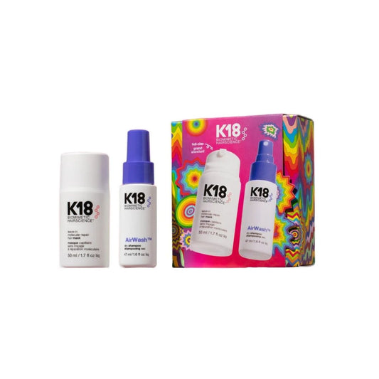 K18 hair care set featuring a white hair building rodent, a white AirWash bottle with a blue spray top, and a colorful box with a psychedelic pattern showing the same products.