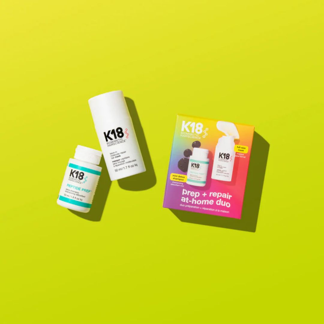 K18 hair care products including bottles and a box on a green background