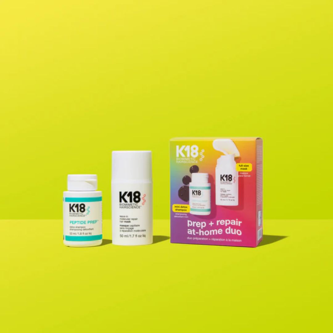 K18 hair care products including bottles and a box on a yellow background