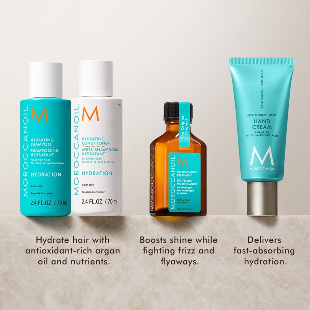 Moroccanoil hair care products including shampoo, conditioner, serum, and hand cream on a neutral background.