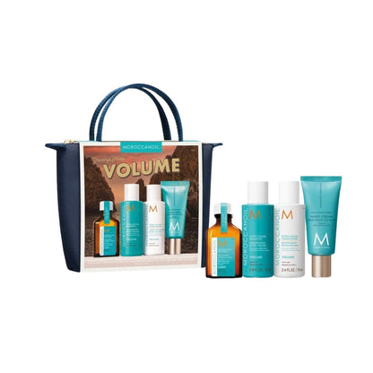 Moroccanoil Volume hair care gift set featuring a navy blue tote bag with a printed insert and six haircare products (two amber bottles, two white bottles, and two teal tubes) displayed on a clean white background.