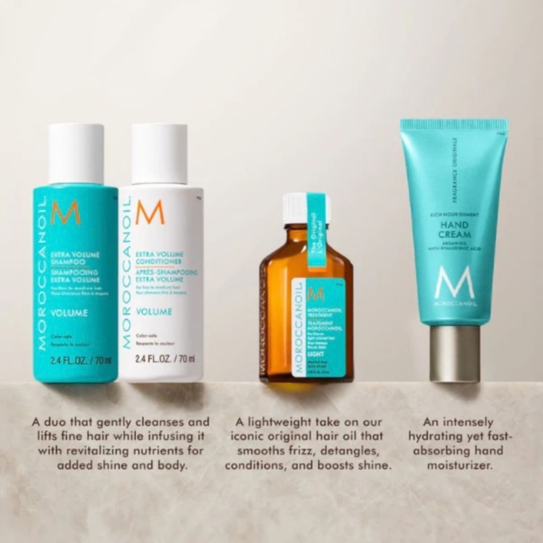 Four Morocaneil hair and hand care products arranged on a light stone surface against a warm beige background: a turquoise and white Volume Cleanser bottle, a white Volume Conditioner bottle, an amber bottle with a turquoise label and silver cap, and a turquoise Hand Cream tube. Product descriptions appear below each item.