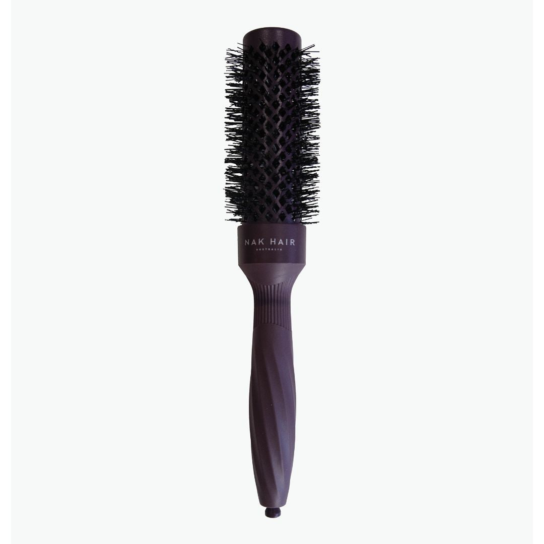 Round hairbrush with bristle head and purple handle on a white background