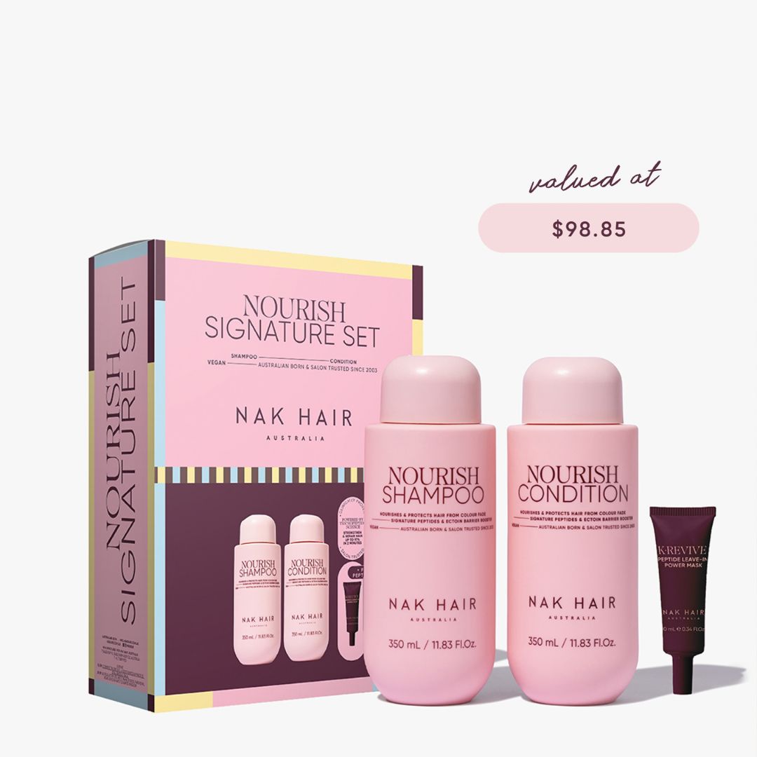 Nak Hair Nourish Signature Set hair care gift set featuring a pink and purple box, two pink bottles of shampoo and conditioner, and a dark purple tube, with a 'valued at $98.85' text overlay on a light gray background.
