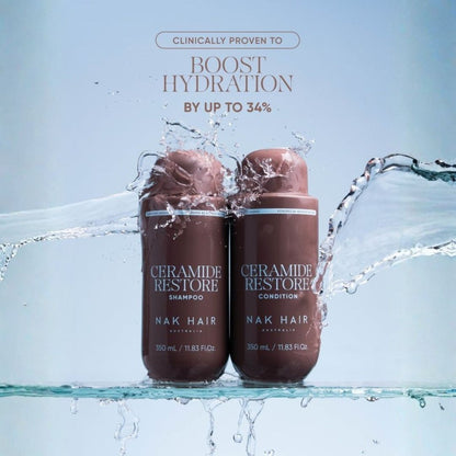 Two brown bottles of Nak Hair Keramide Restore shampoo and conditioner floating in water with splashes, under text that says clinically proven to boost hydration by up to 34%.
