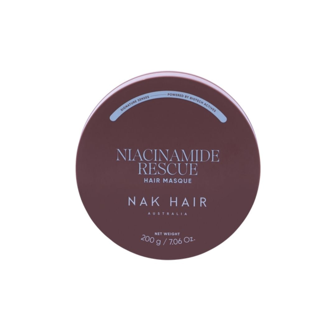 A round tin of Niacinamide Rescue Hair Masque by NAK HAIR, featuring a dark plum-brown lid with white and light blue text, set against a plain white background.