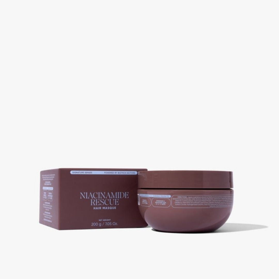 A jar of Niacinamide Rescue Hair Masque next to its matching brown packaging box, set against a clean white background.