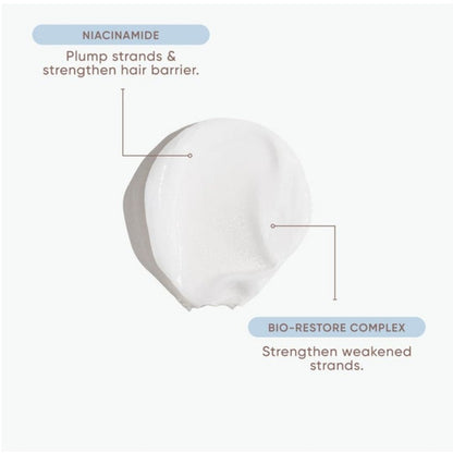 A white cosmetic cream smear on a light gray background with callout text reading 'NIACINAMIDE' and 'BIO-RESTORE COMPLEX' plus descriptive benefits.