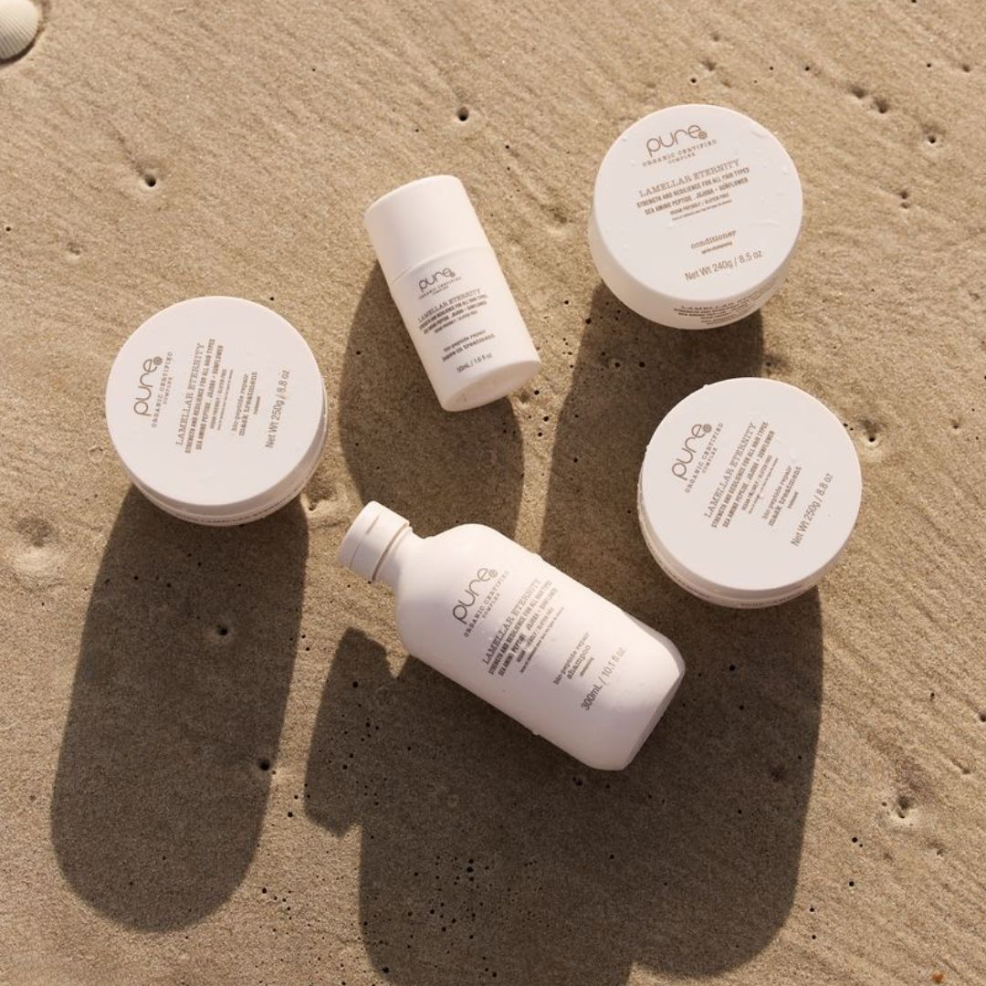 Cosmetic products with 'C.O.F.G.' branding on a sandy surface