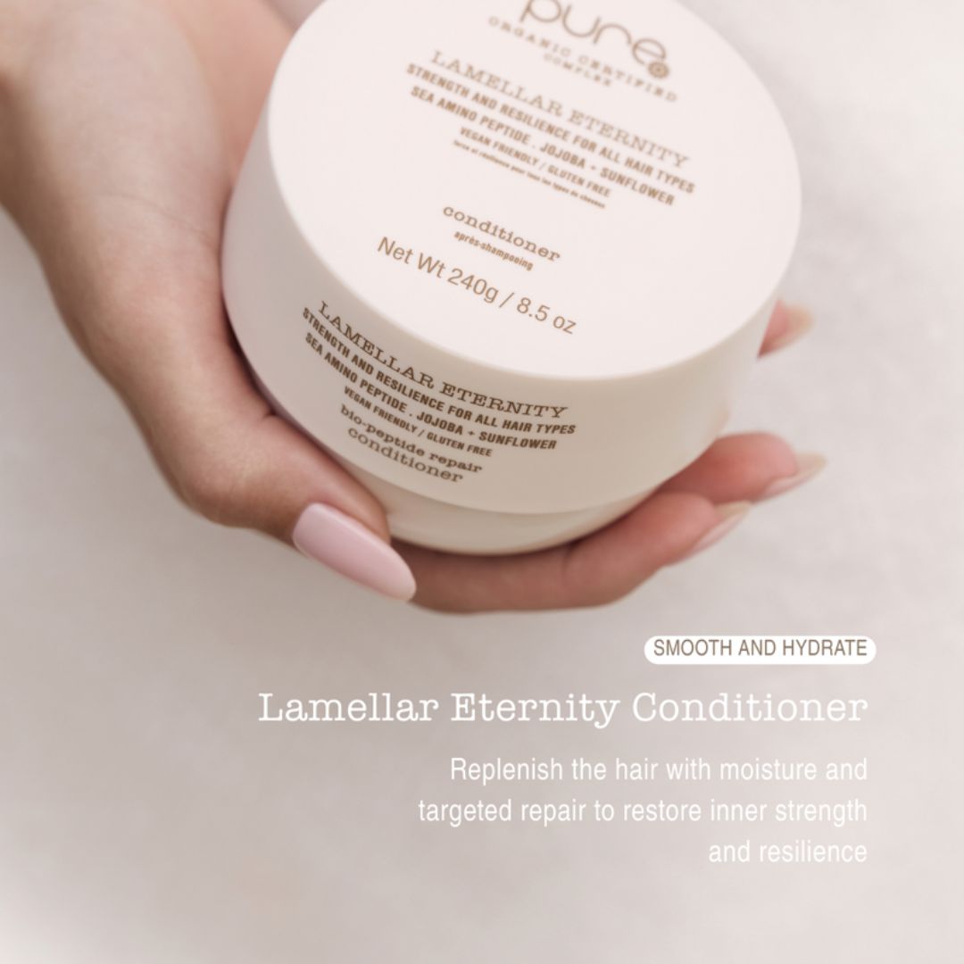Hand holding a container of Lamellar Eternity Conditioner with product details on a light background