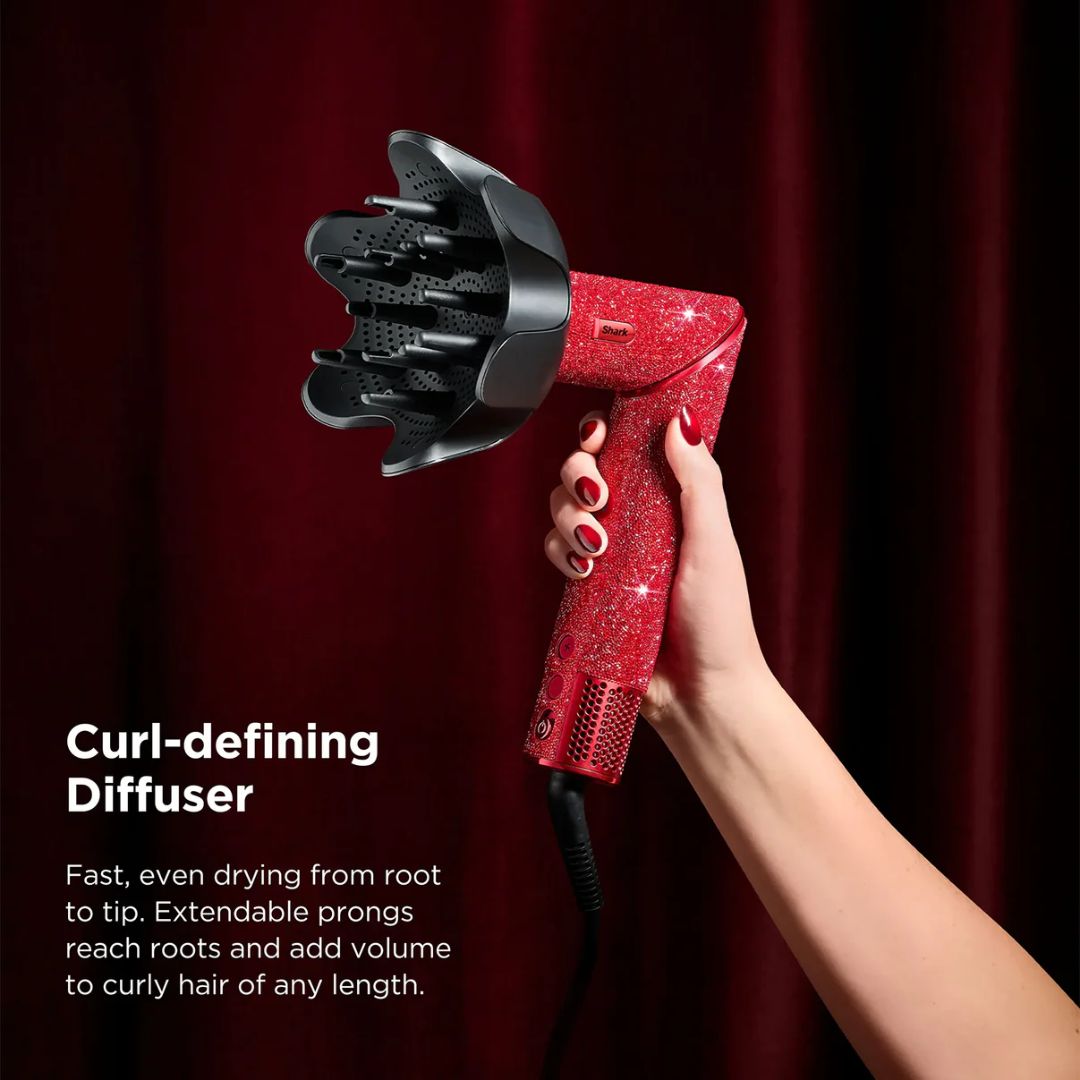 Red curl-defining diffuser held by a hand against a dark background
