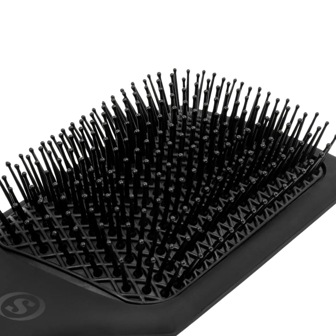 Black hairbrush with bristles on a white background