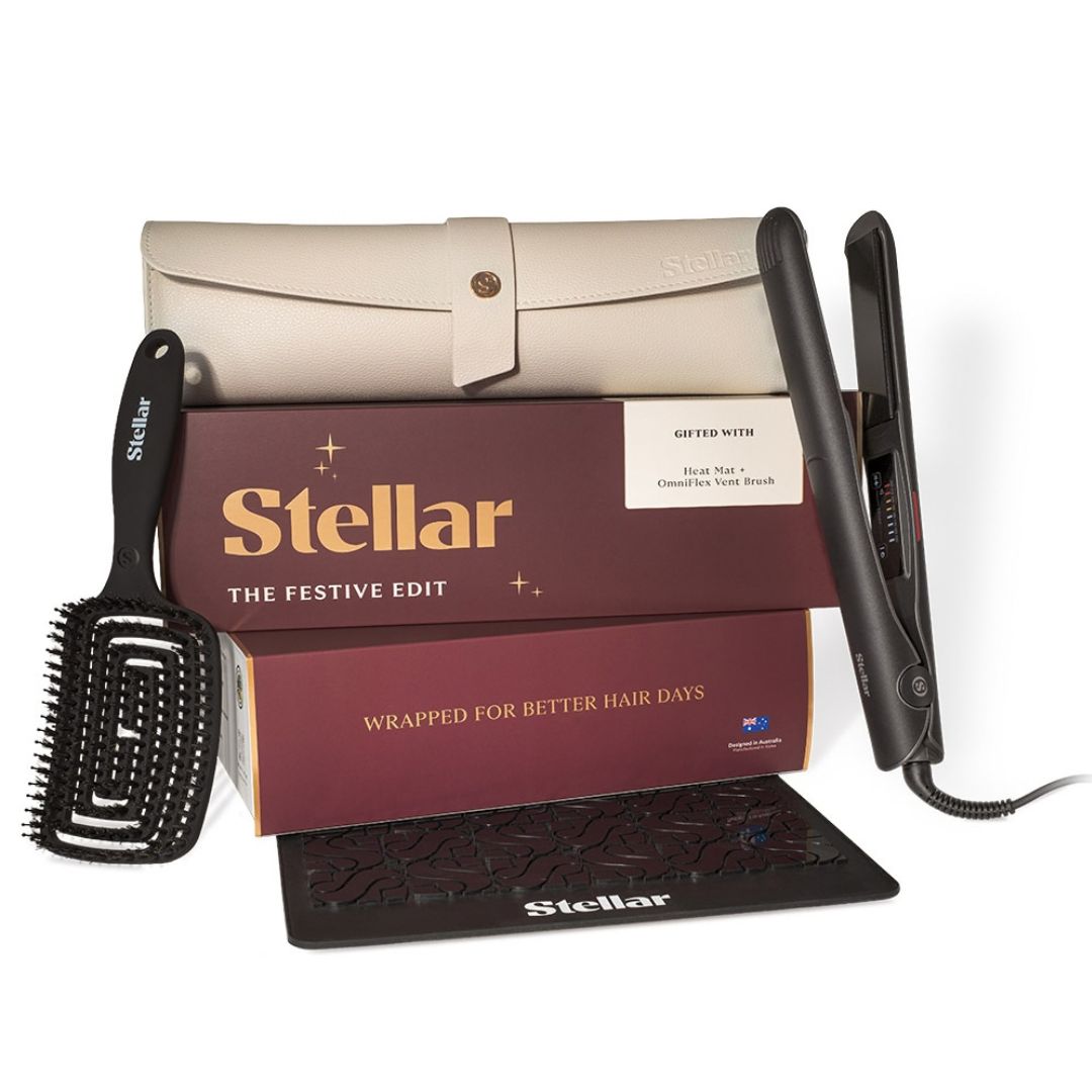 Stellar The Festive Edit hair care gift set featuring a black flat iron, black hair brush, beige storage case, and maroon gift box on a white background.