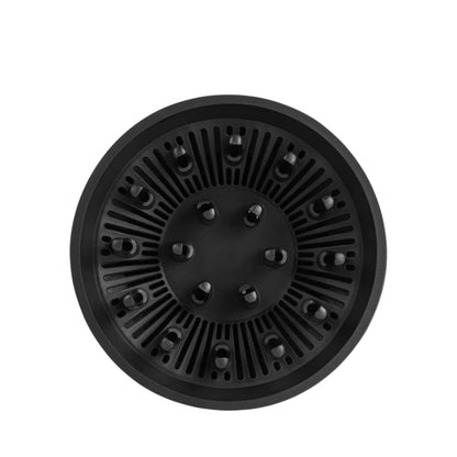 Black circular object with textured surface on a white background