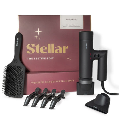 Stellar styling set gift box with a black styling brush, hair dryer, stand, and four black hair clips on a white background.
