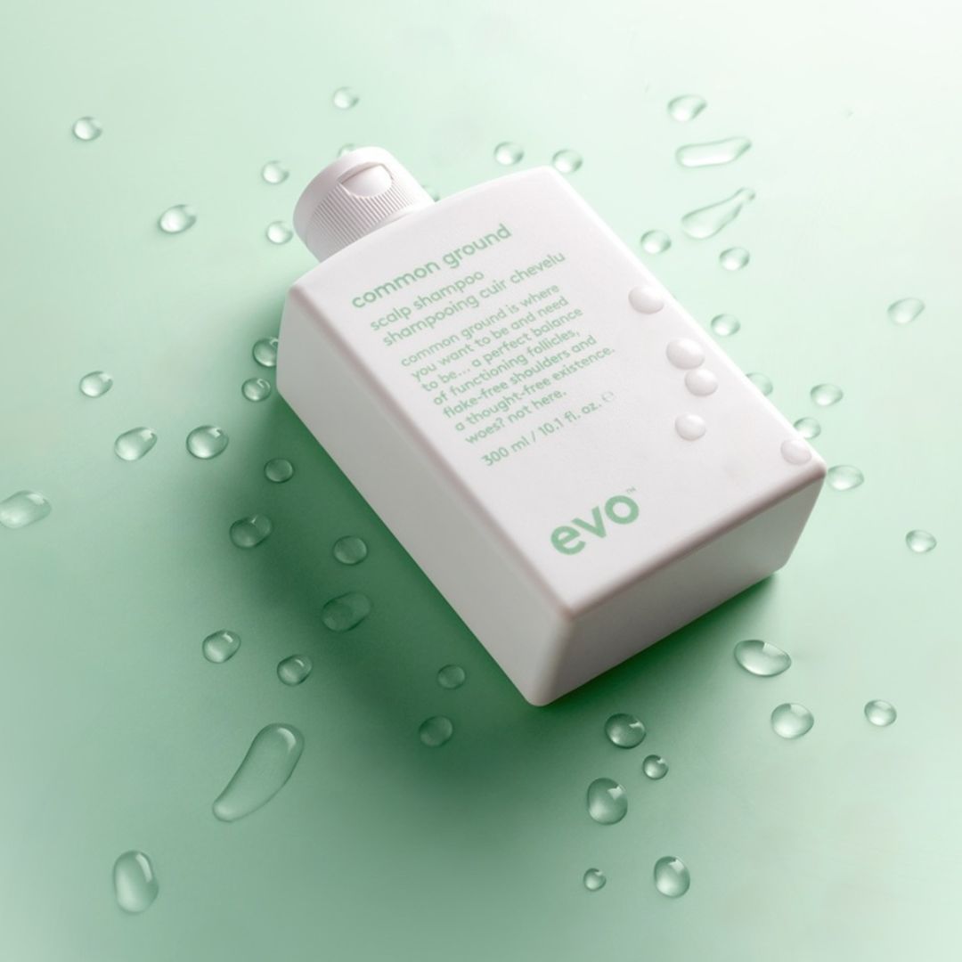 evo shampoo bottle on a green background with water droplets