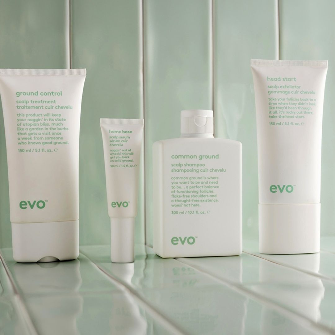 Collection of evo hair care products on a light green tiled background