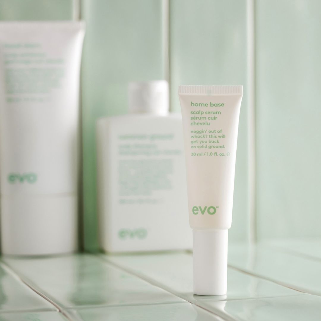 Evo hair care products on a tiled bathroom shelf