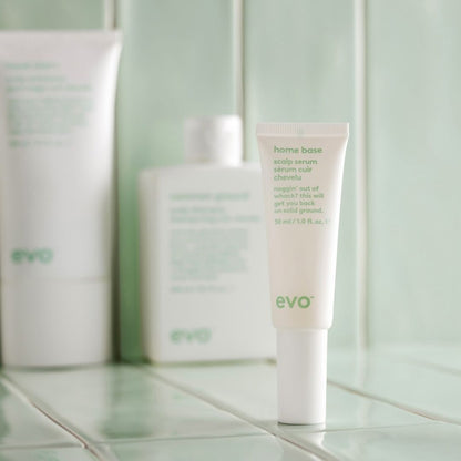 Evo hair care products on a tiled bathroom shelf