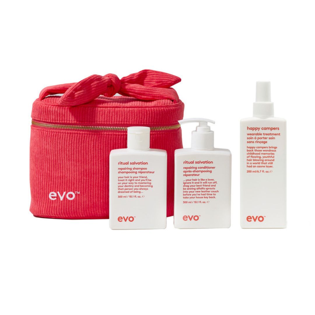 A set of EVO ritual care products including a red zippered carrying case, a ritual salverton shampoo bottle, a ritual salverton conditioner pump bottle, and a happy camper skin rinse spray bottle, all on a white background.