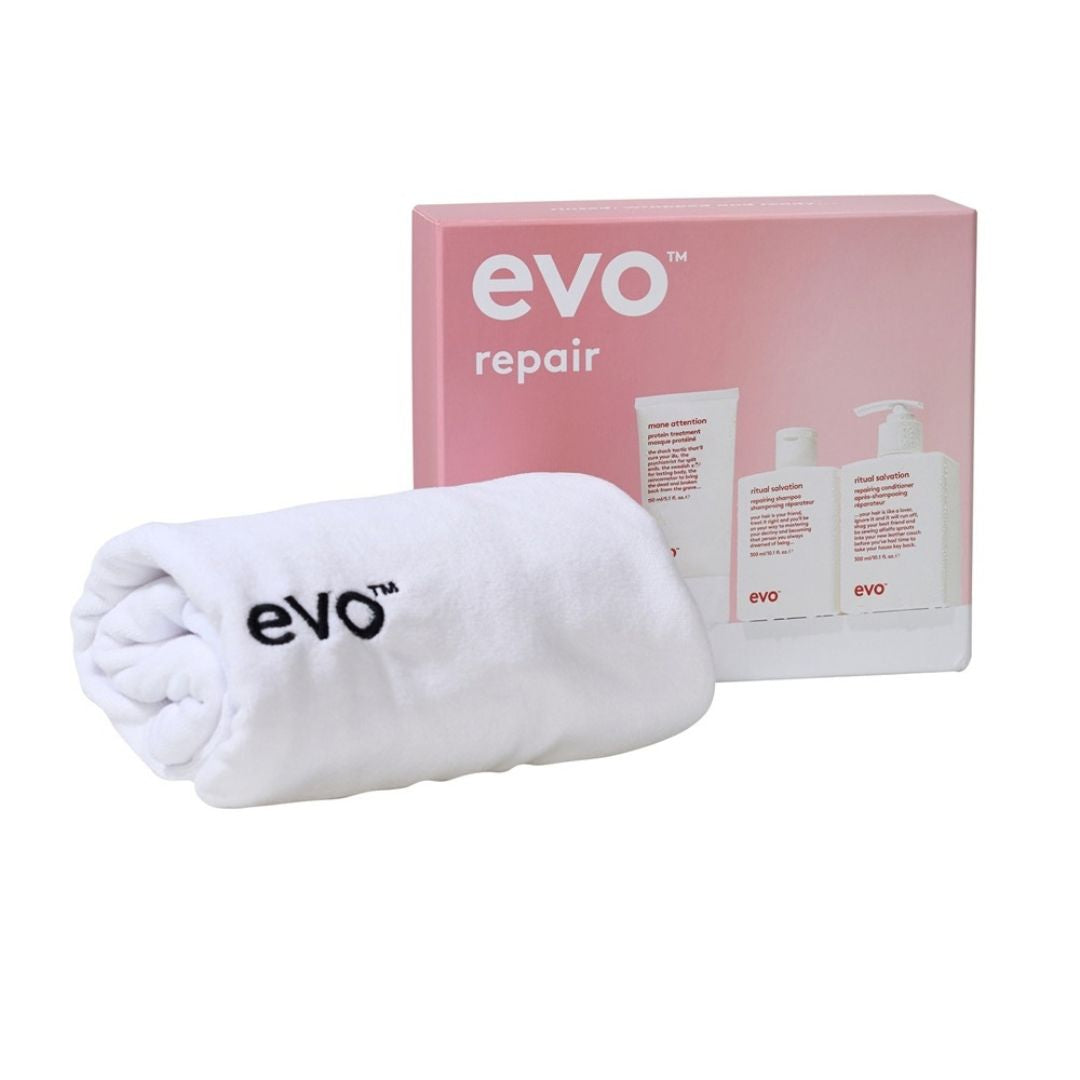 A white rolled towel with the black 'evo' logo in front of a pink and white 'evo repair' product box on a white background.