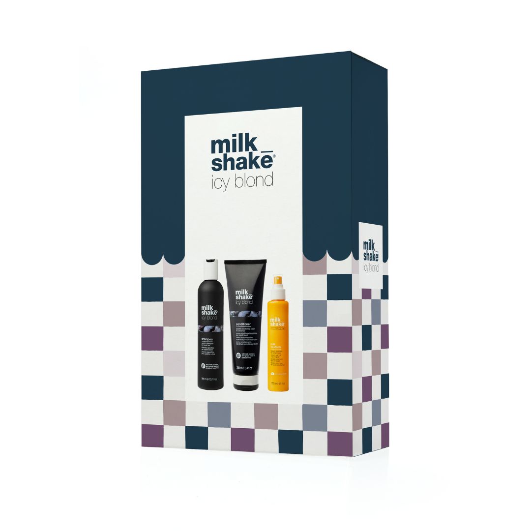 A Milk Shake 'Icy Blond' hair care gift set in a dark navy blue box with a purple, white, and navy checkered pattern on the lower half. The front of the box features images of three black hair products: a shampoo bottle, a hair mask tube, and a yellow-orange conditioner bottle.