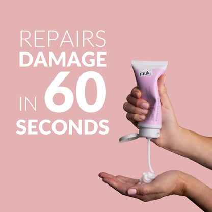 Hand holding a pink muk hair product with text 'Repairs damage in 60 seconds' on a pink background